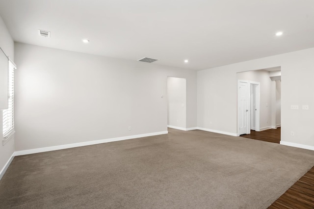 unfurnished room featuring visible vents, baseboards, dark wood-type flooring, and recessed lighting