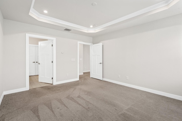 unfurnished bedroom featuring visible vents, recessed lighting, carpet flooring, a raised ceiling, and baseboards