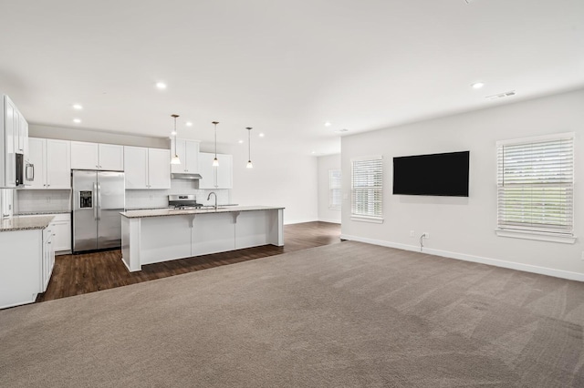 kitchen featuring stainless steel appliances, visible vents, under cabinet range hood, open floor plan, and white cabinets