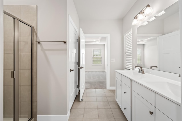 full bathroom featuring a sink, a stall shower, tile patterned flooring, double vanity, and baseboards