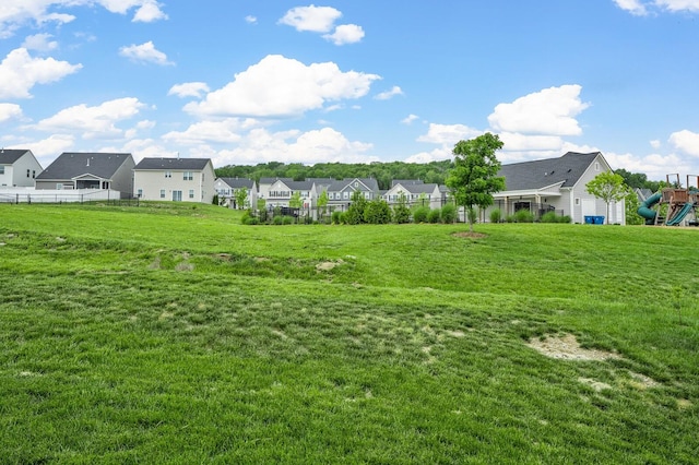 view of yard featuring a residential view, a playground, and fence