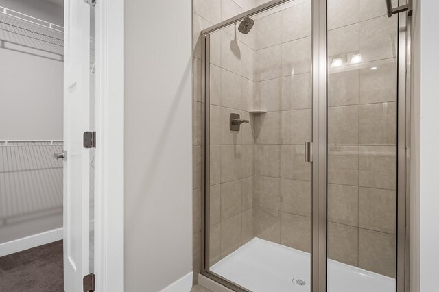 full bathroom featuring baseboards and a shower stall