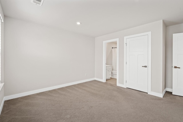 unfurnished bedroom featuring connected bathroom, carpet, baseboards, and visible vents