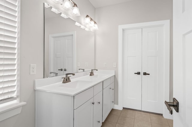 bathroom featuring tile patterned floors, double vanity, and a sink