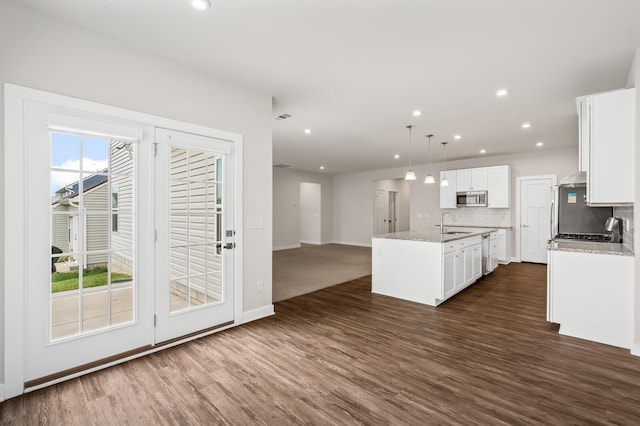kitchen featuring plenty of natural light, stainless steel appliances, baseboards, and dark wood-style floors