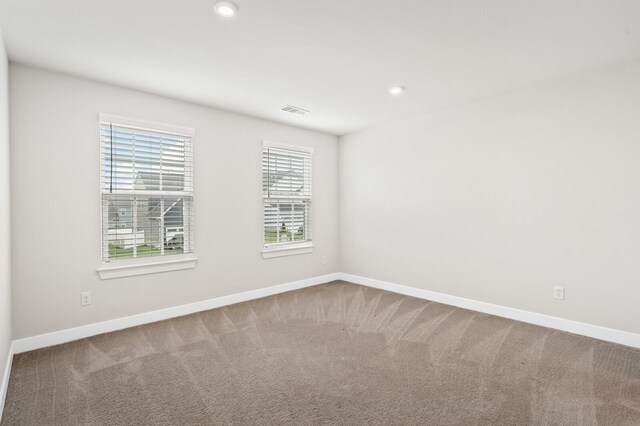 carpeted empty room featuring baseboards, recessed lighting, and visible vents