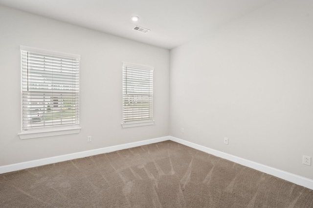 empty room with plenty of natural light, visible vents, and baseboards