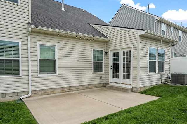 rear view of house featuring a yard, roof with shingles, a patio, and central air condition unit