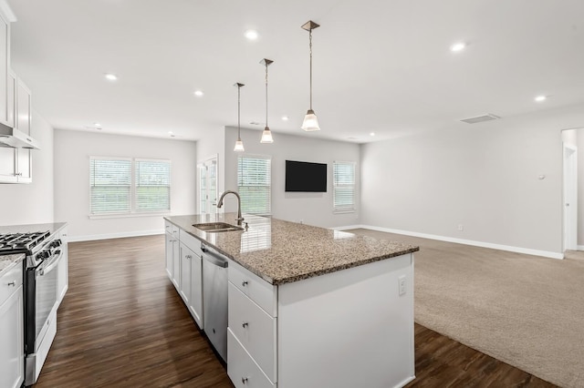 kitchen featuring baseboards, a sink, a center island with sink, white cabinets, and appliances with stainless steel finishes