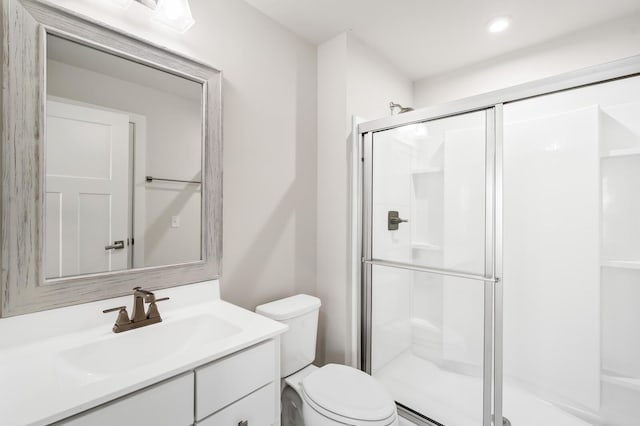 bathroom featuring vanity, toilet, a shower stall, and recessed lighting