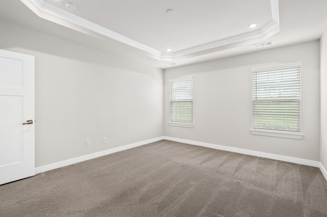 spare room featuring baseboards, a tray ceiling, visible vents, and carpet floors
