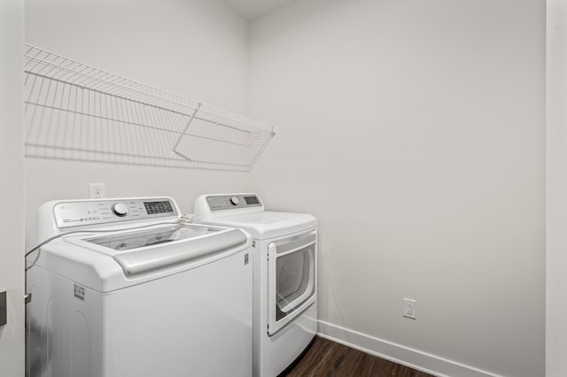 washroom with laundry area, dark wood-style flooring, baseboards, and washing machine and clothes dryer