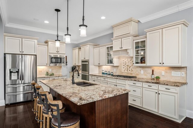 4029 Kings Camp Pass, Arrington, TN 37014 - kitchen with stainless steel appliances, cream cabinets, a sink, an island with sink, and hanging light fixtures