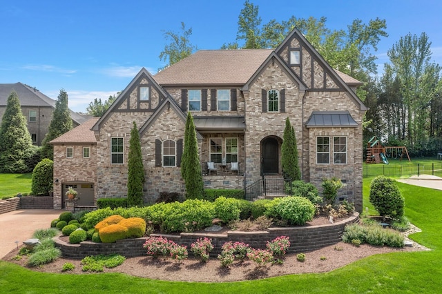 4029 Kings Camp Pass, Arrington, TN 37014 - tudor-style house featuring an attached garage, driveway, a front lawn, brick siding, and a shingled roof
