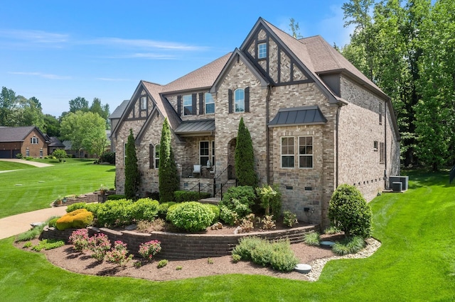 4029 Kings Camp Pass, Arrington, TN 37014 - tudor house featuring a front yard, brick siding, a standing seam roof, and central air condition unit