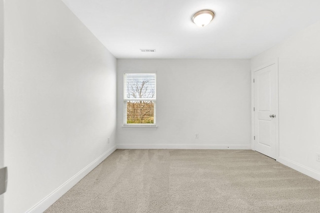 unfurnished room with baseboards, visible vents, and light colored carpet