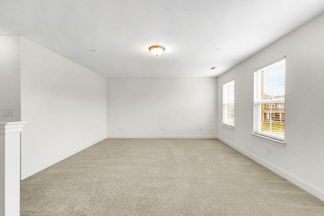 empty room with baseboards and light carpet
