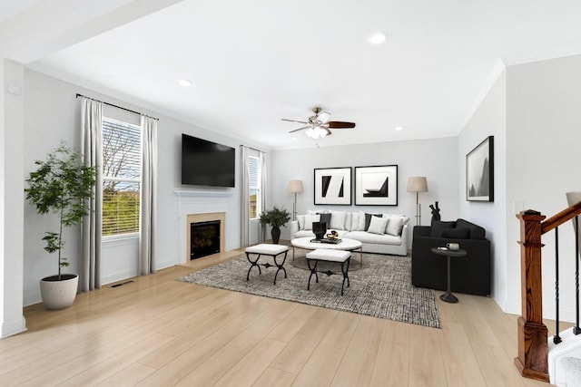 living area with stairs, light wood-type flooring, recessed lighting, a fireplace, and ceiling fan