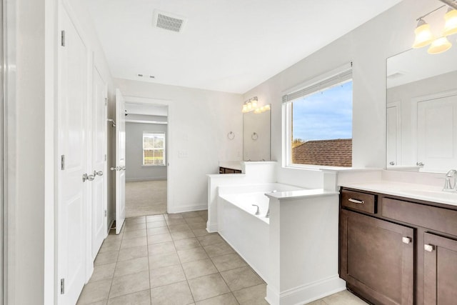 full bath featuring baseboards, visible vents, tile patterned flooring, a garden tub, and vanity