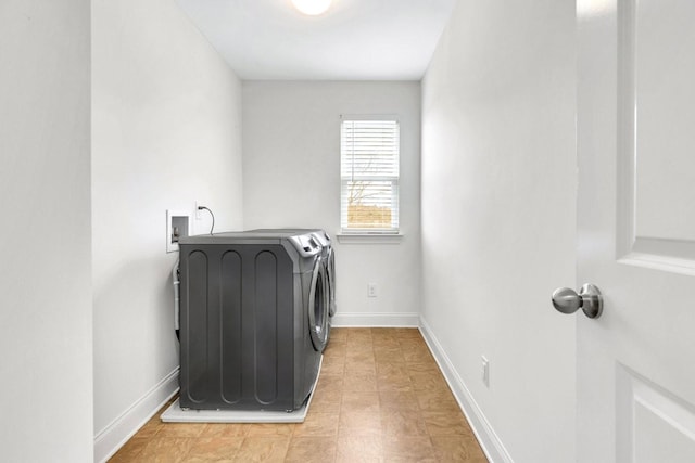 clothes washing area with laundry area, light tile patterned floors, baseboards, and washing machine and dryer