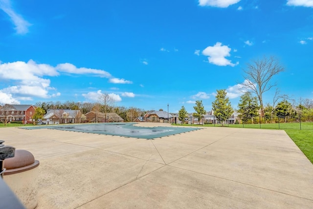 view of swimming pool featuring a patio area, a residential view, a fenced in pool, and fence