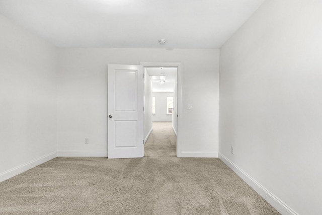 carpeted empty room with baseboards