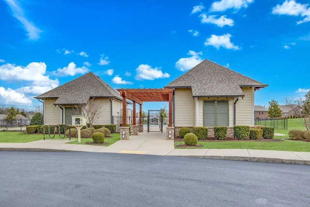 view of front of property with a gate, fence, and a shingled roof