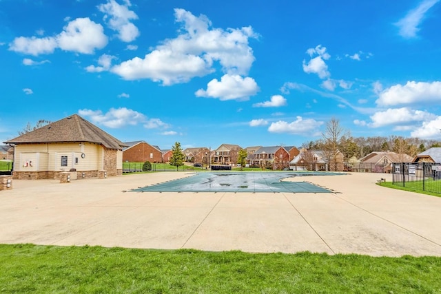 pool featuring fence, a patio area, and a residential view