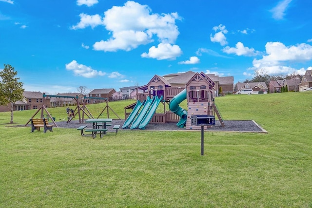communal playground featuring a residential view and a lawn