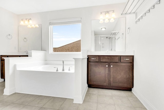 bathroom featuring vanity, tile patterned flooring, a shower stall, baseboards, and a bath