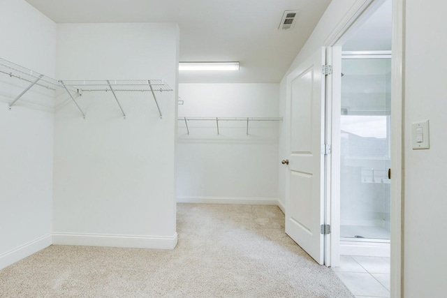walk in closet featuring visible vents and carpet floors