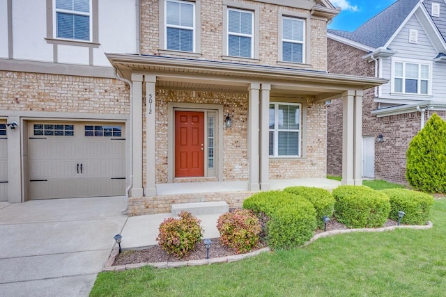 view of exterior entry featuring concrete driveway, a porch, brick siding, and an attached garage