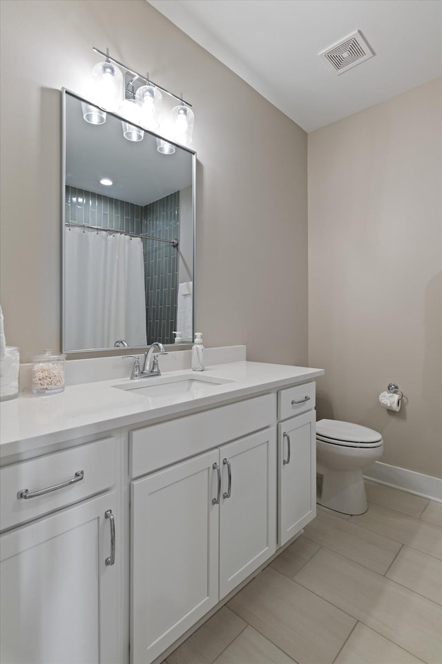 bathroom featuring vanity, toilet, a shower with curtain, and visible vents