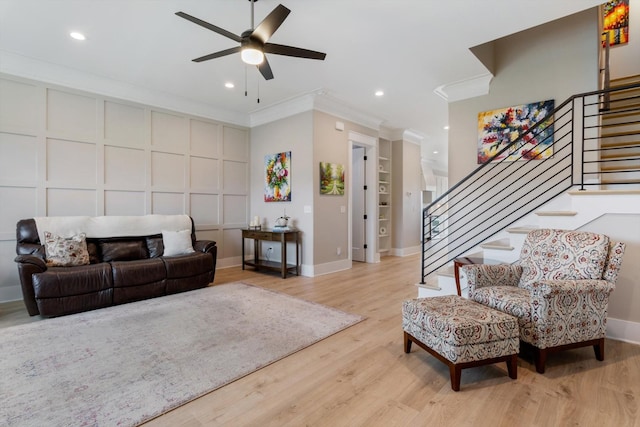 living area featuring recessed lighting, ornamental molding, ceiling fan, stairs, and wood finished floors