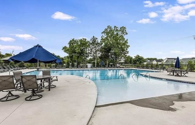 community pool with fence and a patio
