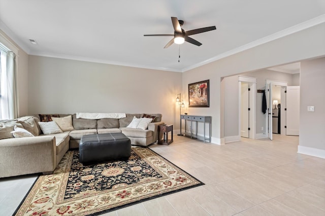 living room featuring a ceiling fan, ornamental molding, light tile patterned floors, and baseboards