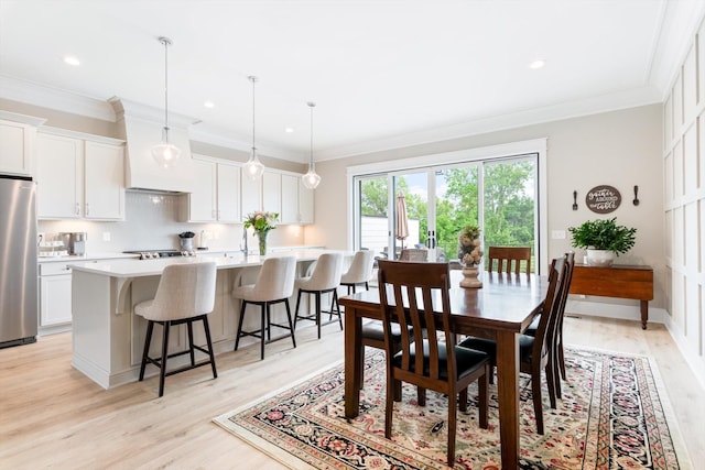 dining area with ornamental molding, light wood-style flooring, and recessed lighting