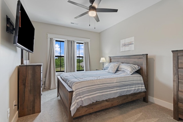 bedroom featuring baseboards, ceiling fan, light carpet, and visible vents