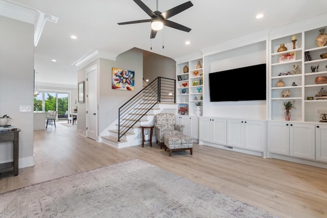 living room featuring a ceiling fan, stairway, light wood finished floors, and baseboards