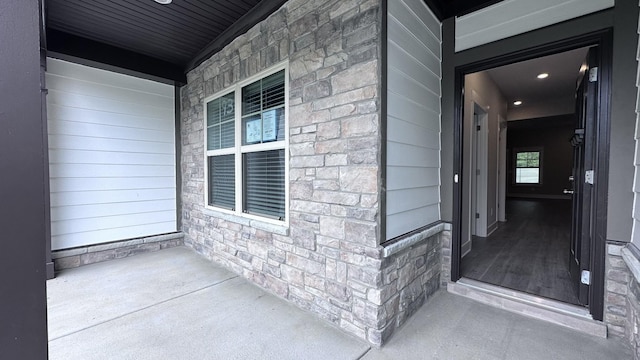 entrance to property with stone siding and covered porch