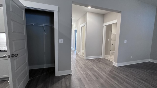 unfurnished bedroom featuring baseboards, a closet, and wood finished floors