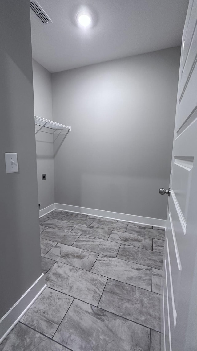 laundry area featuring marble finish floor, laundry area, hookup for an electric dryer, visible vents, and baseboards
