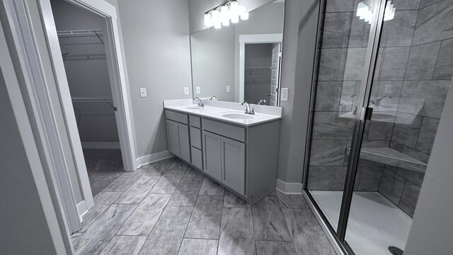 full bath featuring baseboards, a stall shower, and a sink
