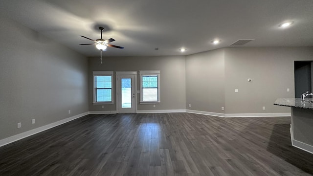 unfurnished living room with a ceiling fan, visible vents, dark wood-style flooring, baseboards, and recessed lighting