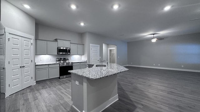 kitchen with a ceiling fan, a sink, gray cabinets, baseboards, and appliances with stainless steel finishes