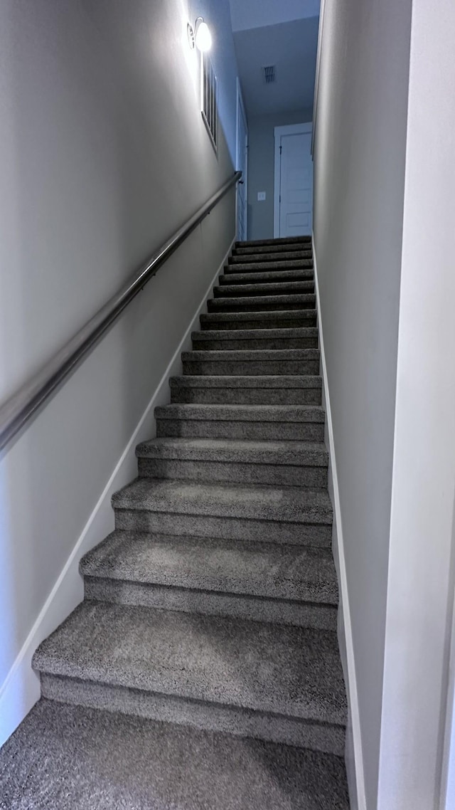 staircase featuring visible vents and carpet floors