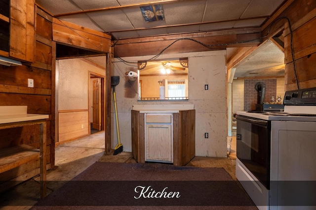 kitchen featuring a wood stove, ceiling fan, and electric range