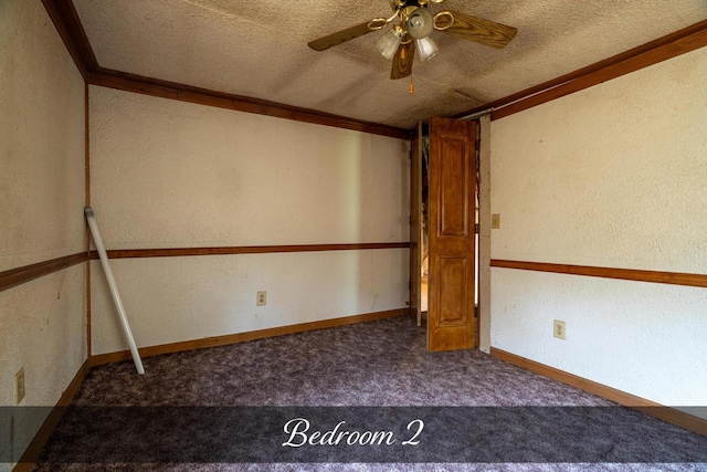 carpeted spare room with crown molding, a textured ceiling, and a ceiling fan