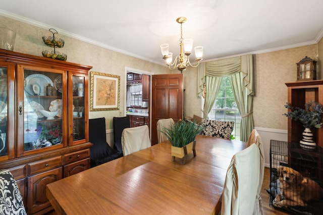dining room featuring baseboards, ornamental molding, and a notable chandelier