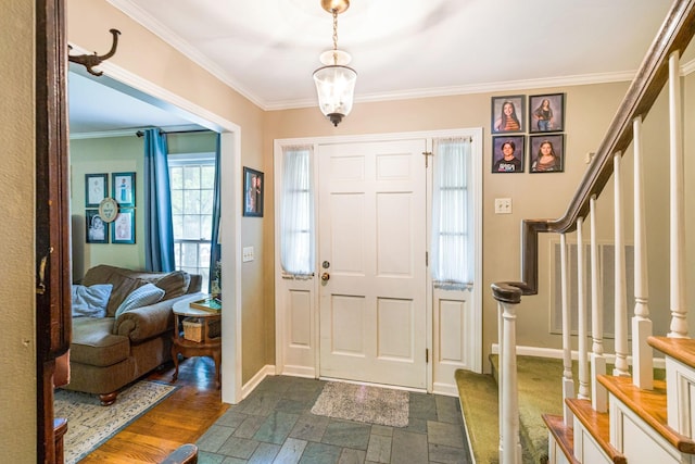 foyer entrance with crown molding, stairs, and stone tile flooring